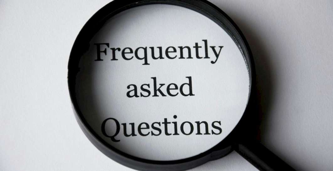 Magnifying glass highlighting the words Frequently Asked Questions, symbolizing help and support section