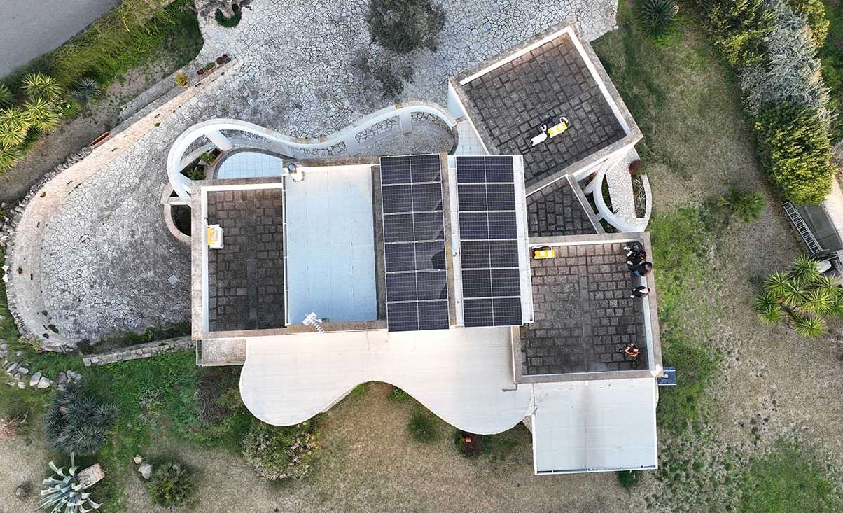 Aerial view of a modern residential flat-roof villa with rooftop solar panels by Solavita, seamlessly integrated into the architecture